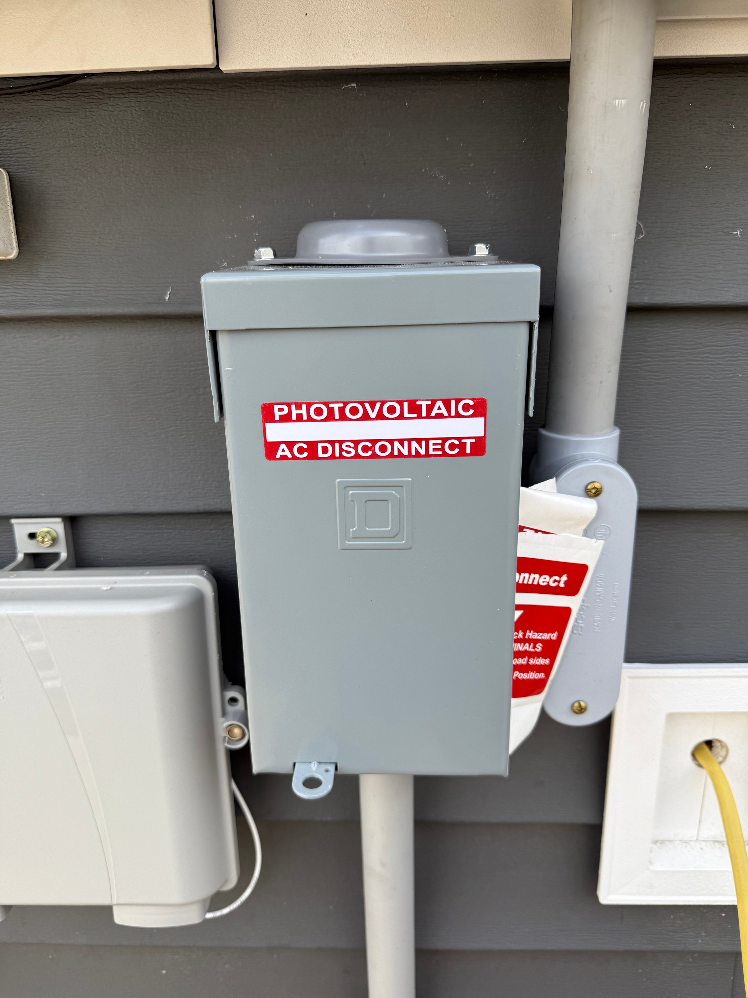 Solar power system AC disconnect switch mounted on exterior wall